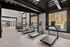 Modern gym with large windows revealing a scenic outdoor view, featuring multiple treadmills and exercise equipment for a refreshing workout experience.
