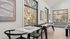 Chic recreational room with elegant board game table, large windows offering scenic forest views, and modern art adorning the walls.