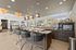 Luxurious modern lounge featuring sleek bar seating, stylish pendant lights, and panoramic windows with natural views.