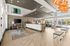 Spacious and modern lobby featuring sleek lighting, cozy seating areas, and a large TV, with natural light streaming through expansive windows.