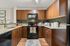 Modern kitchen with sleek wooden cabinetry, granite countertops, and stainless steel appliances, perfect for culinary enthusiasts.