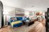 Inviting open-concept living space with a cozy blue sofa, vibrant artwork, and a modern dining area, perfect for stylish living and entertaining.