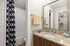 Chic bathroom featuring a granite countertop, modern fixtures, and a stylish navy patterned shower curtain.