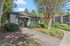 Charming residential building surrounded by lush greenery and a picturesque pathway, creating a serene and welcoming atmosphere.
