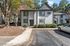 Charming apartment building with modern exterior, surrounded by lush greenery and ample parking space.