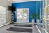 Inviting fitness room with a bright blue accent wall, large windows, yoga mats, and vibrant exercise balls.