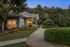 Charming apartment exterior with lush landscaping, elegant pathway, and warm ambient lighting for a serene atmosphere.