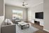 Bright and modern living room with elegant decor, featuring a cozy sofa, stylish armchair, and a large TV for entertainment.