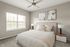 Inviting bedroom with elegant decor, featuring a cozy bed, modern nightstands, and soft natural light through large windows.