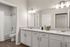 Sleek bathroom design featuring dual sinks, granite countertops, and ambient lighting.