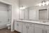 Elegant bathroom with pristine granite countertops, dual sinks, and a sleek bathtub in a modern setting.