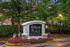 Inviting entrance to Arbor Place Apartments, surrounded by lush greenery and vibrant flower beds, creating a welcoming ambiance.