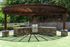 Charming outdoor grilling area with a stylish stone bar under a rustic wooden pergola, set against a lush green backdrop.
