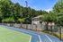 Charming apartment with scenic views overlooking a lush green tennis court and vibrant trees.
