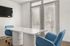 Indoor community office space with table, chsirs, and TV