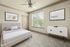 Bright and airy bedroom featuring a plush bed, modern decor, and a large window with tranquil views.