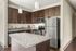 Modern kitchen with elegant dark wood cabinets, sleek stainless steel appliances, and a stylish granite countertop island.