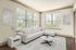 Bright and elegant living room featuring a chic white sectional couch, modern coffee table, and large windows with serene views.