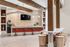 Chic communal kitchen with modern bar seating, stylish pendant lights, and warm wood accents ideal for social gatherings.