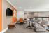 Elegant communal living space featuring contemporary decor, stylish seating, and vibrant orange accents.
