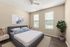 Inviting bedroom with modern decor, plush bedding, stylish artwork, and natural light from large windows.