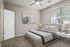 Inviting bedroom with modern decor, featuring a plush bed, elegant artwork, and abundant natural light from a large window.