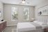 Bright and modern bedroom with elegant decor, featuring large windows, a plush bed, and stylish furnishings.