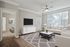 Modern apartment living room with elegant white furniture, stylish decor, and abundant natural light from large windows.