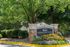 Charming Creekside Vista entrance surrounded by lush greenery and vibrant flowerbeds, welcoming you to a serene apartment community.