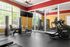 Bright and modern fitness center featuring state-of-the-art exercise equipment, expansive windows, and vibrant decor.