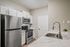 Modern kitchen with sleek stainless steel appliances, elegant white cabinetry, and a stylish marble countertop with a contemporary faucet.