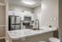 Modern kitchen with sleek stainless steel appliances, elegant marble countertops, and stylish white cabinetry.