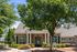 Charming residential building with elegant stone facade, lush landscaping, and welcoming front entrance.