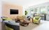 Chic and modern lounge area with stylish chairs, geometric wood accent wall, and large windows offering abundant natural light.