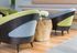 Chic modern seating area with stylish armchairs and a rustic wooden side table, accented by fresh flowers for a touch of elegance.