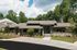 Charming single-story building with modern architecture and lush greenery, perfect for a tranquil lifestyle.
