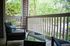 Charming outdoor patio with cozy seating, perfect for relaxing and enjoying lush green views.