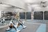 Modern gym featuring exercise bikes, climbing wall, and a variety of fitness equipment in a bright and spacious setting.