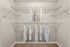 Spacious walk-in closet with stylish wooden flooring, featuring tidy closet organization and ample shelving.