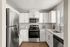 Modern kitchen with sleek stainless steel appliances, elegant white cabinetry, and spacious countertops under natural light.