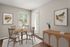 Charming dining area with natural light, featuring elegant wooden furniture, artistic wall decor, and a serene ambiance.