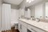 Elegant bathroom with modern fixtures, granite countertop, and sleek white cabinetry for a refined living experience.
