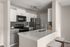 Modern kitchen with sleek white cabinets, stainless steel appliances, and a stylish breakfast bar with seating.
