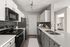Modern kitchen with sleek countertops, stainless steel appliances, and a cozy bedroom view in an elegant open-plan apartment.
