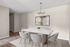 Elegant dining area featuring a chic marble table, plush chairs, and contemporary artwork, highlighted by a modern chandelier. Perfect for stylish entertaining.