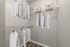 Spacious walk-in closet with ample shelving and hanging space, featuring neatly organized shirts and storage boxes.