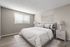 Bright bedroom with stylish decor, featuring a comfortable bed and contemporary nightstand, complemented by natural wood flooring.