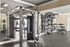 Modern fitness center equipped with state-of-the-art gym machines, free weights, and exercise balls, offering a sleek and inviting workout environment.