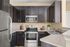 Modern kitchen with sleek dark cabinets, stylish stainless steel appliances, and elegant granite countertops.