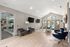 Chic apartment lounge with modern seating, sleek decor, and a view of the pool through glass doors.